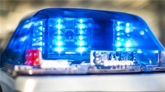 Das Blaulicht an einem Polizeiwagen ist eingeschaltet. 