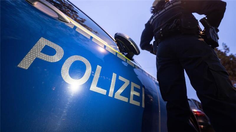 Autokorso auf A27 - Riskantes Manöver zwingt Polizei zur Vollbremsung Eine Polizistin steht neben einem Polizeifahrzeug. (zu dpa: «Schüsse aus Autokorso - Polizeieinsatz in Bremen»)