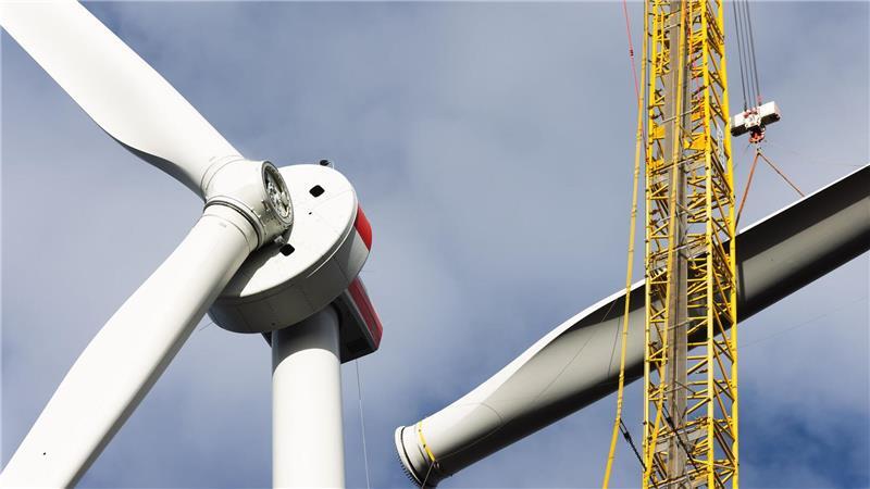 Symbolbild: Ein Kran zieht das Rotorblatt einer neuen Windkraftanlage hoch - bald vielleicht auch an der A26 am Rand des Alten Landes.