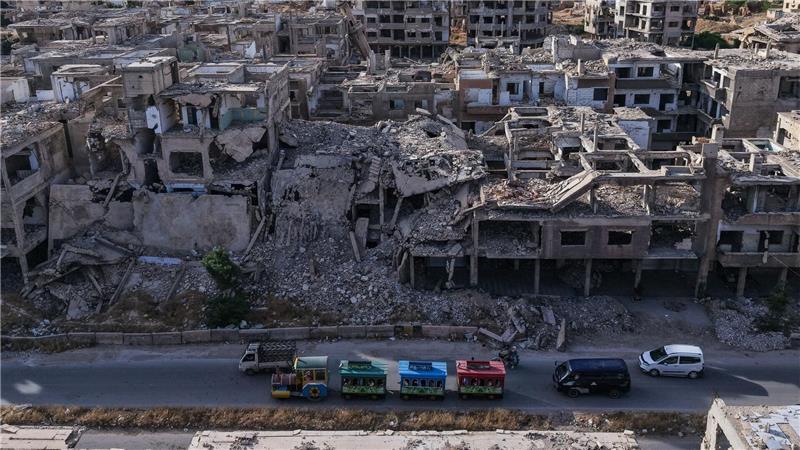 Syrer fahren in einer bunten Eisenbahn am zweiten Tag des muslimischen Opferfestes Eid al-Adha in einem Vergnügungspark in einem verwüsteten Gebiet inmitten des völlig zerstörten Stadtteils Jobar am Stadtrand von Damaskus.
