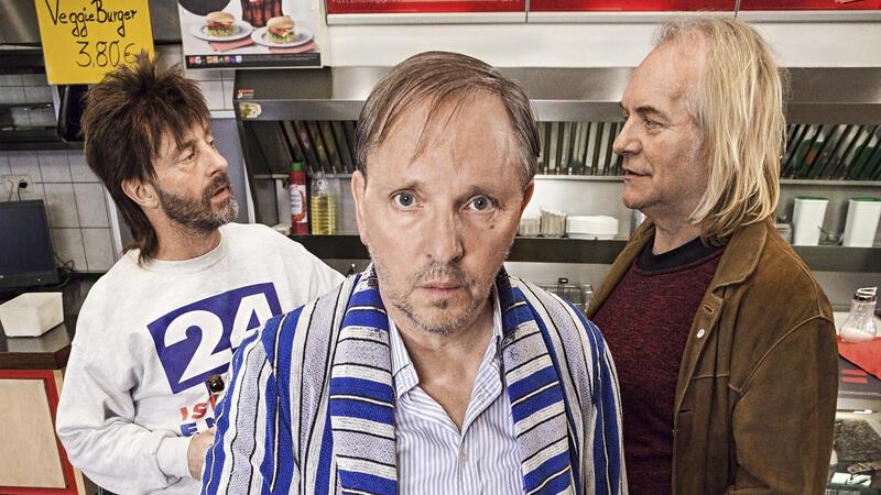 Szene aus der WDR-Comedy „Das wirklich wahre Leben“ in der Eppendorfer Grillstation mit Dittsche (Olli Dittrich, vorn), Wirt Ingo (Jon Flemming Olsen, l) und Krötensohn Jens (Jens Lindschau, r).