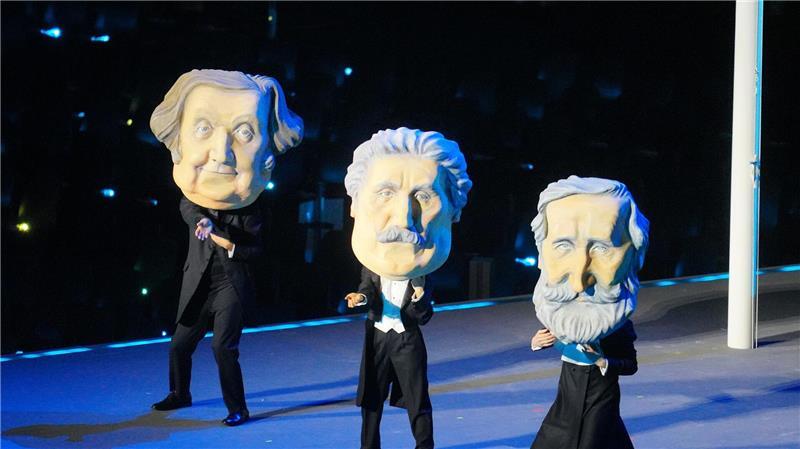 Italien feiert Olympia-Eröffnung als knallbunte Oper Tänzer mit Masken würdigten die italienischen Komponisten Giuseppe Verdi, Giacomo Puccini und Gioachino Rossini.