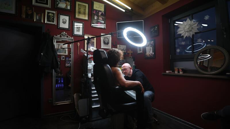 Tattoos nach Brustkrebs - Fast wie die eigene Brustwarze Tattoo-Künstler Andy Engel (r) tätowiert der Brustkrebspatientin Anja D. eine Brustwarze.