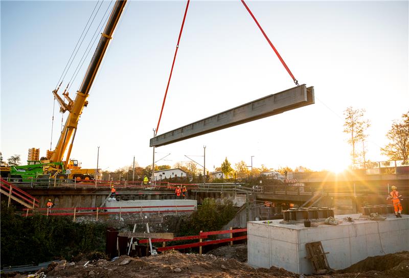 Teile einer Brücke werden auf der Baustelle der neuen S-Bahn-Linie S4 im Stadtteil Marienthal mit einem Kran eingehoben. Die neue S4 soll bis 2029 Hamburg mit Bad Oldesloe verbinden. Foto: Daniel Bockwoldt/dpa