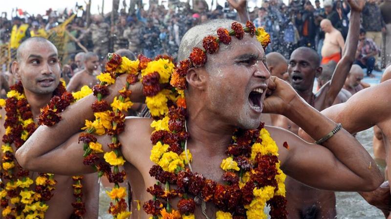 Teilnehmer beim Hindu-Fest Maha Kumbh Mela in Indien - heilige Männer beim heiligen Bad am heiligen Ort. 