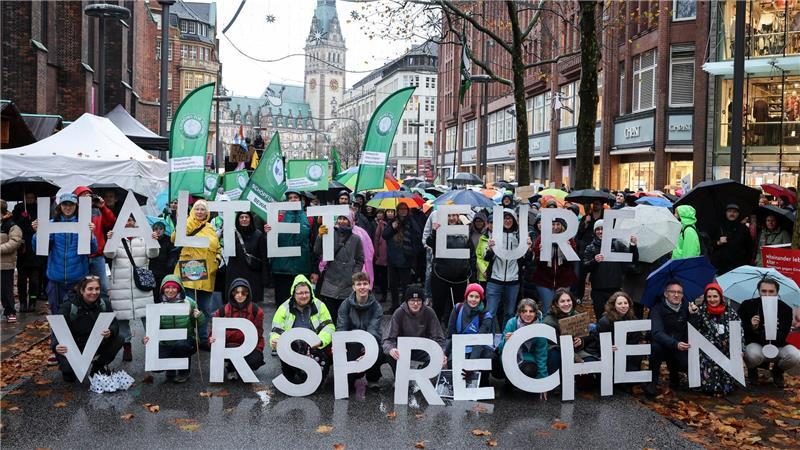 Teilnehmer der Demonstration in Hamburg halten Buchstaben, die einen Slogan ergeben. 