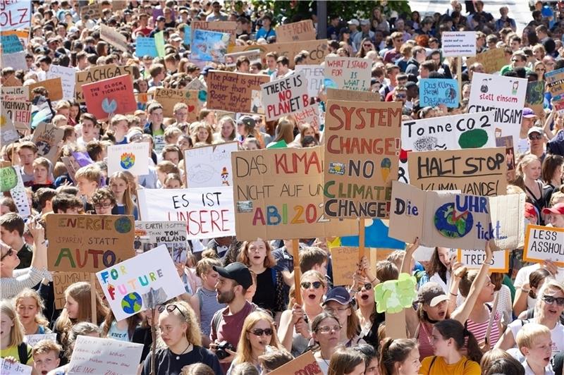Teilnehmer der Klima-Demonstration „Fridays for Future “ halten auf dem Gänsemarkt unter anderem Transparente mit der Aufschrift: „System change! No climate change!“ oder „Die Uhr tickt...“ hoch. Foto: Wendt/dpa