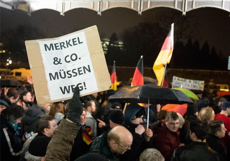 Teilnehmer der Protestveranstaltung "Merkel muss weg" demonstrieren auf dem Dammtorplatz vor dem Bahnhof Dammtor in Hamburg. Foto: Christian Charisius/dpa
