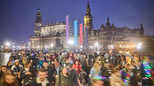 Teilnehmer des Spazierclubs laufen am Abend durch Dresden.