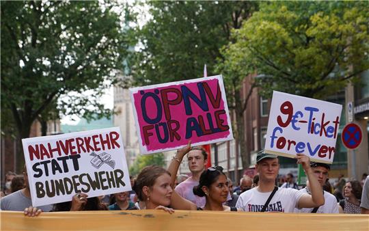 Teilnehmer einer Demonstration des Bündnisses «9-Euro-Ticket-forever!» gehen durch die Innenstadt. Das Bündnis setzt sich für einen dauerhaft günstigen Nahverkehr ein. Foto: Marcus Brandt/dpa