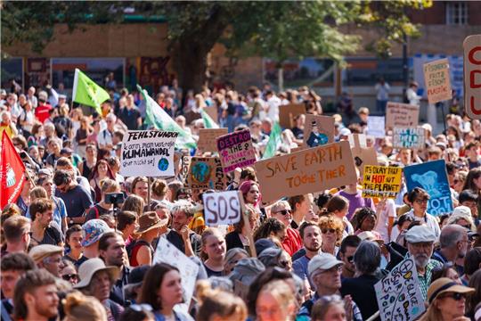 Teilnehmer einer Demonstration gegen den Klimawandel und für Klimagerechtigkeit stehen auf dem Platz der Alten Synagoge in Freiburg.