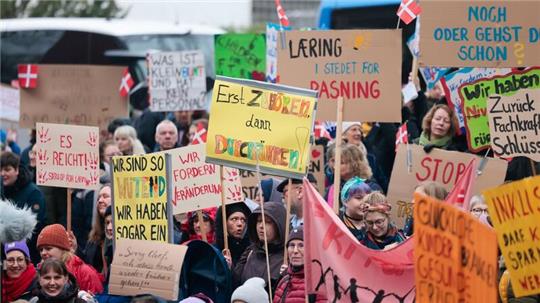 Teilnehmer einer Demonstration stehen vor dem Kieler Landtag.