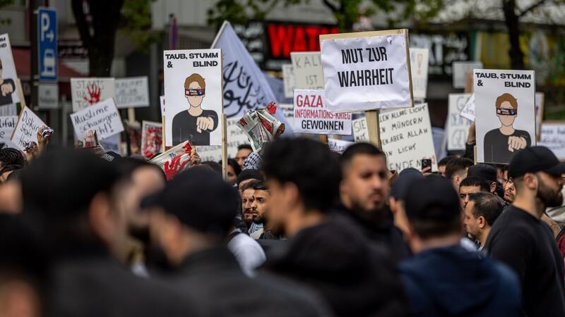 Teilnehmer einer Islamisten-Demo halten ein Plakat mit der Aufschrift „Mut zur Wahrheit“ in die Höhe.