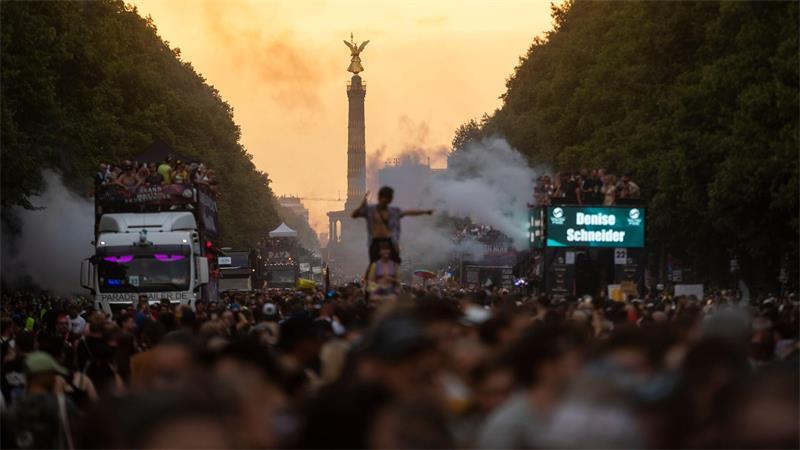Teilnehmer tanzen bei der Demonstration „Rave The Planet Parade 2026“ während die Sonne untergeht.