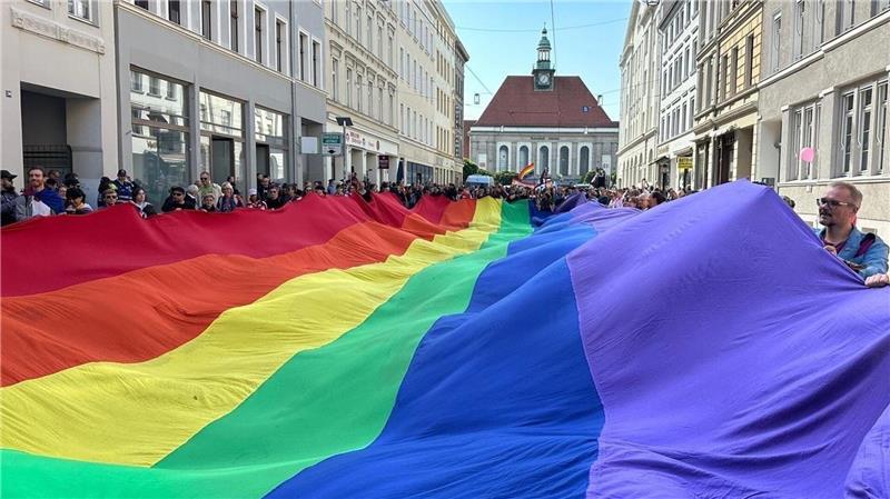 Teilnehmer ziehen mit einer überdimensionalen Regenbogenfahne beim 4. Christopher Street Day (CSD) durch die Stadt. 
