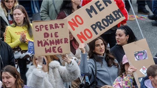 Teilnehmerinnen einer feministischen Demonstration äußern ihre Meinung auf Plakaten.