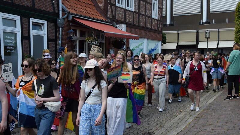 Teilweise in bunter Kleidung und mit Transparenten ziehen die Menschen durch die Stader Altstadt.