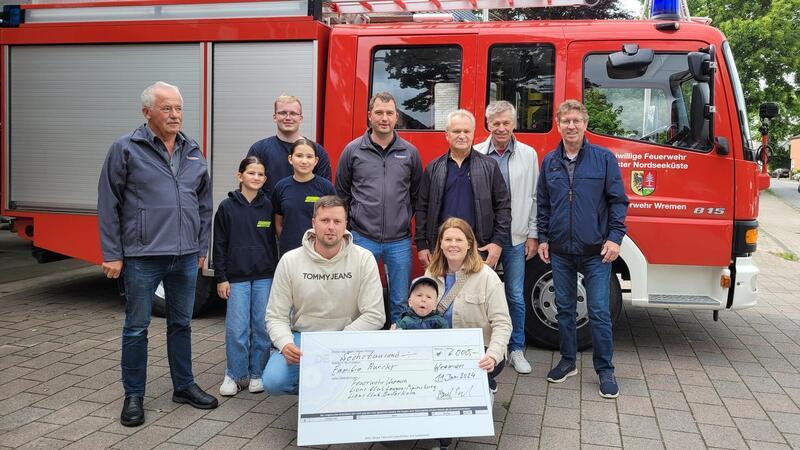 Theo und seine Eltern Berit und Marcel Bursky freuen sich mit der Feuerwer und dem Lions Club.