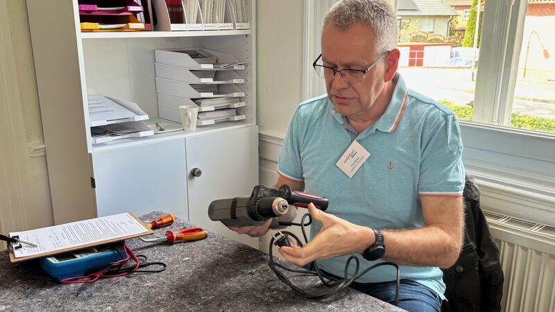 Thomas Heins repariert eine Bohrmaschine.