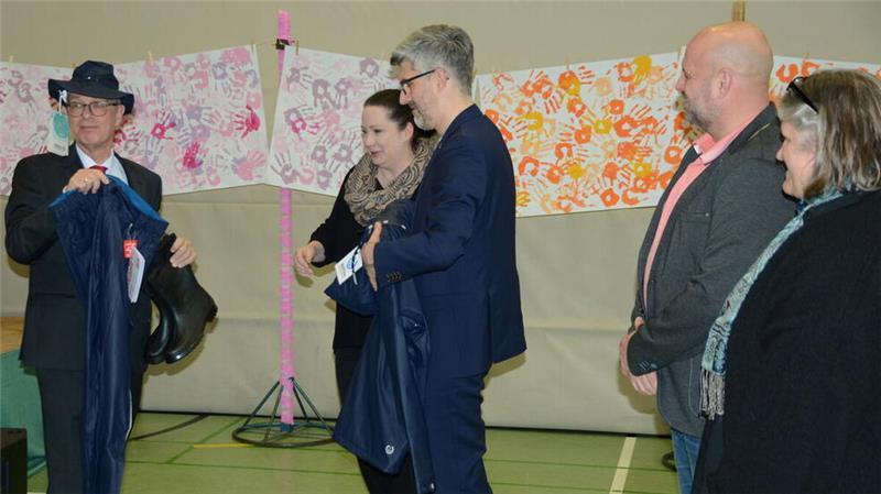 Thomas Kranenberg (links) mit den wetterfesten Kleidungsstücken, von den Gummistiefeln bis zum Hut, die ihm das Kollegium des Gymnasiums Warstade zum Abschied schenkte. Als Fährmann auf der Oste wird er die Ausrüstung brauchen können.