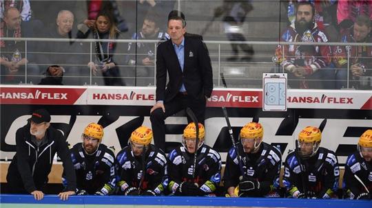 Thomas Popiesch (M,oben), Trainer der Pinguins Bremerhaven, verfolgt das Spiel.