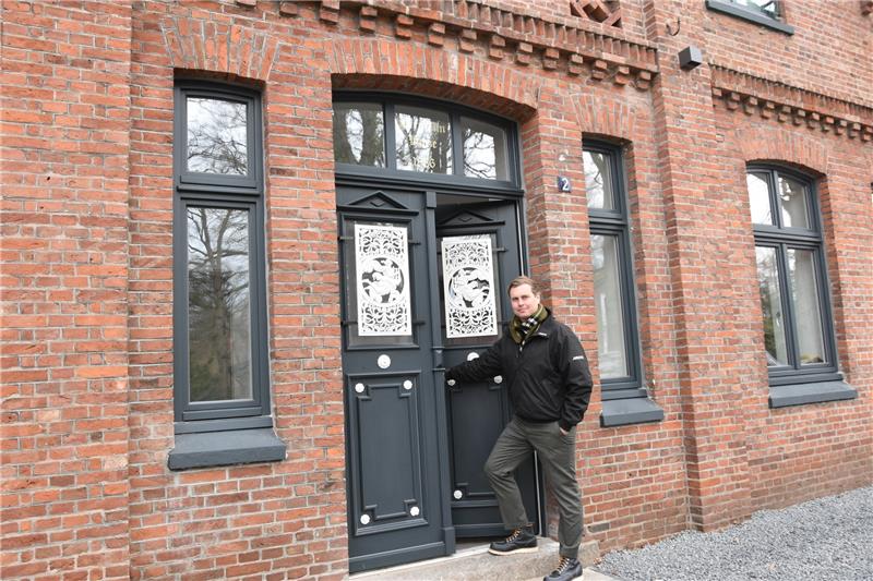 Tim Schulenburg an der liebevoll restaurierten Eingangstür des alten Bauernhauses. Die Buxtehuder Architekten haben die alte Hofstelle zu einem stilvollen Ensemble fürs Wohnen im Grünen gemacht. Foto: Felsch