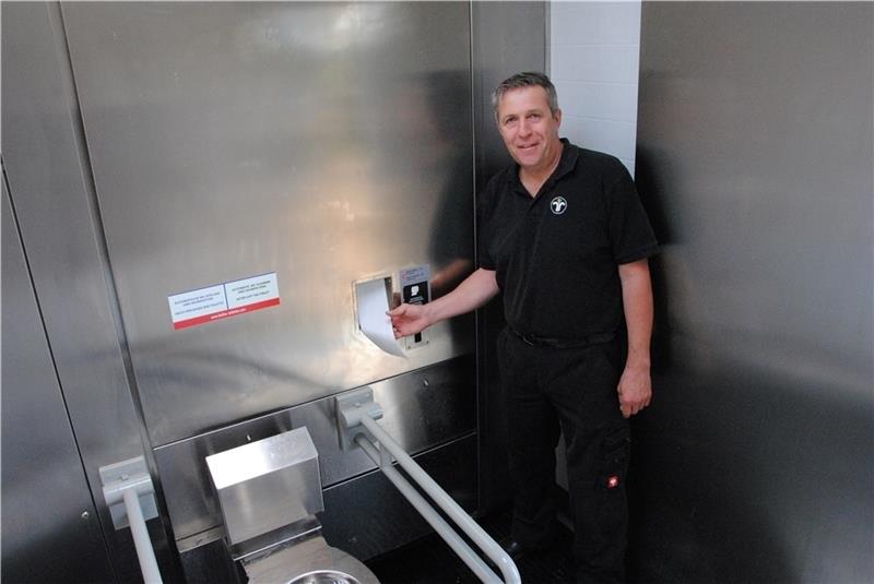 Timo Gerke im Toilettenraum am Klopapierspender.