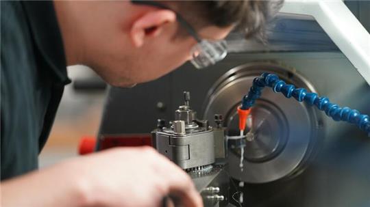 Tjark Merker, Auszubildender zum Zerspanungsmechaniker, arbeitet an einer Drehmaschine in der Auszubildenden-Werkstatt des Schreibgeräteherstellers Montblanc.