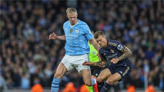 Toni Kroos (r) und Erling Haaland lieferten sich mit Real Madrid und Manchester City ein enges Duell.