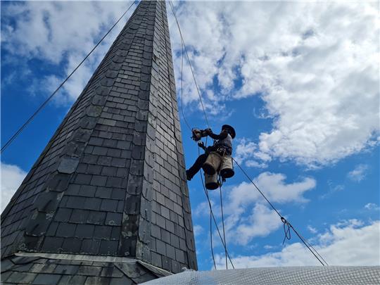 Torben Hasenberg lässt sich in über 20 Metern Höhe den Kirchturm der St.-Martin-Kirche hinaufziehen. Den Aufstieg erleichtert ihm das Seilmoped in seiner linken Hand. Foto: Stahmann
