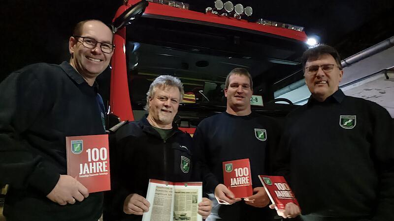 Torsten Bluschke (von links), Torsten Ropers, Arndt Seeba und Ernst-Wilhelm Cordes mit der 100-Jahre-Chronik.
