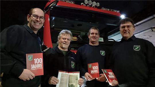 Torsten Bluschke (von links), Torsten Ropers, Arndt Seeba und Ernst-Wilhelm Cordes mit der 100-Jahre-Chronik.