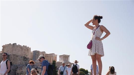 Touristen auf dem Aeropagous-Hügel vor der antiken Akropolis im Zentrum Athens.