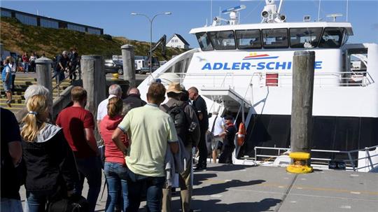 Touristen steigen im Hafen in Hörnum auf Sylt auf den Passagier-Katamaran „Adler Cat“.