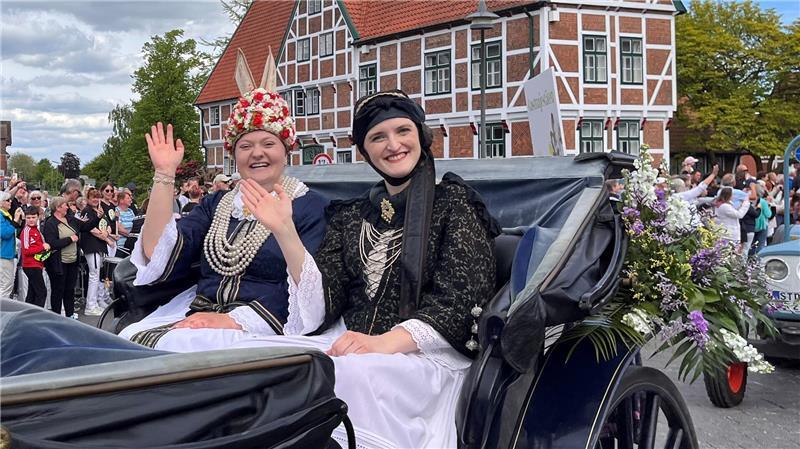 Tradition: Die Altländer Blütenkönigin 2025/2026, Ella Weilert, winkt mit ihrer Vorgängerin Linn Schuback den Massen beim Blütencorso durch Jork zu (von links).