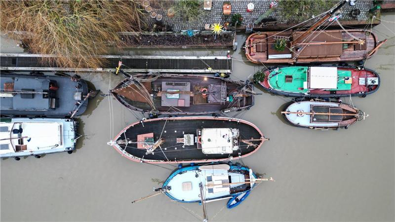 Traditionsschiffe liegen im grauen Wasser im Hafen von Leer.