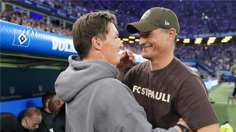 Trainer Alexander Blessin (r, FC St. Pauli) und Trainer Merlin Polzin (Hamburger SV) begrüßen sich vor dem Derby in der Hinrunde. (Archivbild)