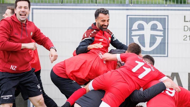 Trainer Nils Zielesniak (links) feiert mit dem Team nach dem 2:0-Siegtreffer.