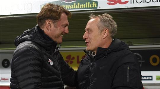 Trainer Ralph Hasenhüttl (l) von Leipzig und Trainer Christian Streich (r) von Freiburg umarmen sich vor der Partie.