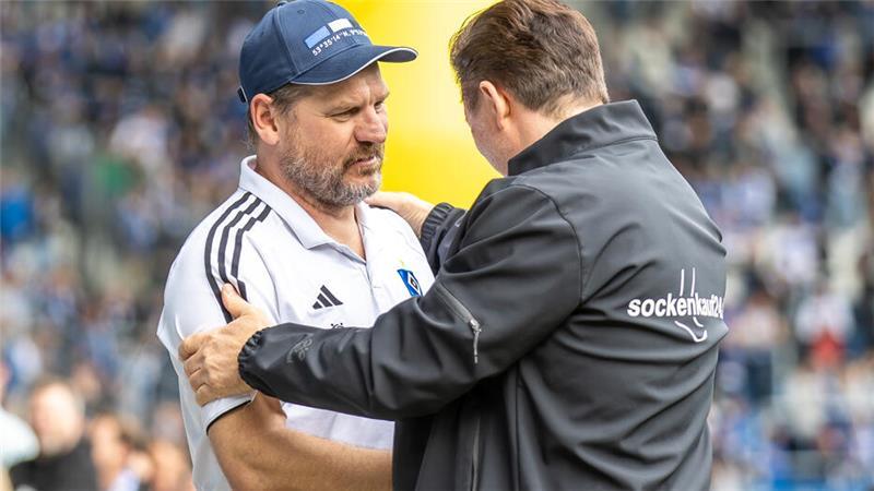 Trainer Steffen Baumgart von Hamburger SV wird begrüßt von Magdeburgs Trainer Christian Titz (r).