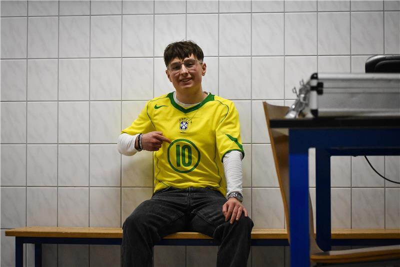 Jupp Hesse im gelben Brasilien-Trikot von Ronaldinho hält einen Ball mit dem rechten Fuß in der Kabine des TSV Großenwörden hoch.