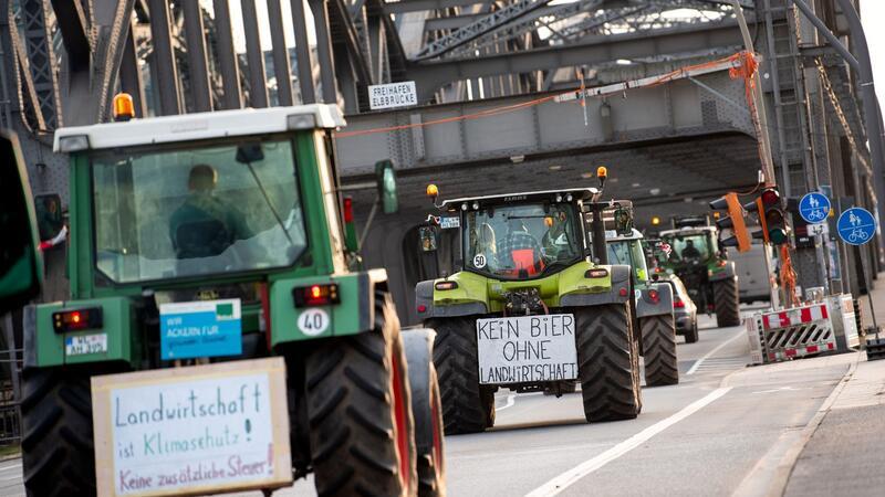 13 Ermittlungsverfahren nach Bauernprotesten im Hamburger Hafen Traktoren mit Schildern fahren über die Freihafenelbbrücke.