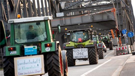 Traktoren mit Schildern fahren über die Freihafenelbbrücke.