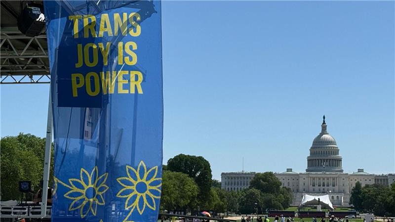 Angst, Widerstand - Wie Transpersonen unter Trump leben „Trans joy is power“ steht auf einem Banner an einer Bühne vor dem Kapitol am ersten Tag der Worldpride.