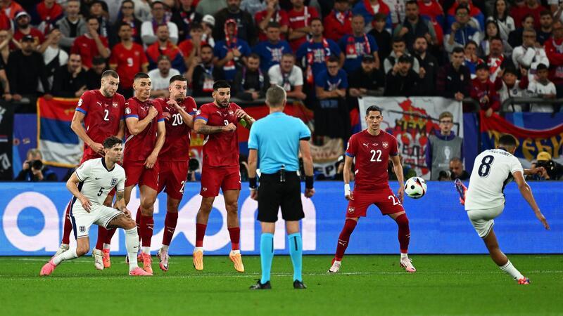 Trent Alexander-Arnold (r) tritt einen Freistoß.