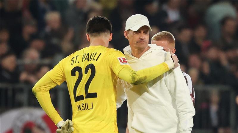 Fehler gegen Freiburg ärgert Pauli-Torwart Vasilj Trost vom Trainer: St. Paulis Torwart Nikola Vasilj mit Alexander Blessin (r).
