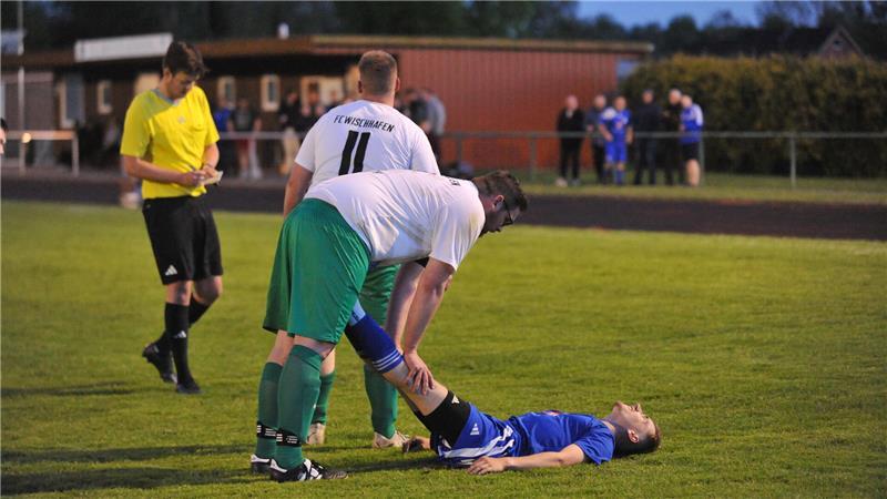 Trotz der Rivalität: FC-Kapitän Mats Junge hilft seinem Gegenspieler Tom Elfers, der wegen Krämpfen auf dem Rasen liegt.