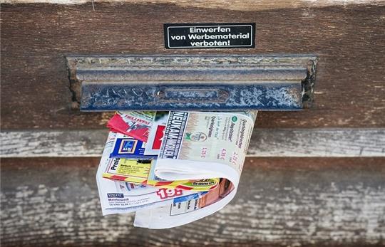 Trotz des Hinweises "Einwerfen von Werbematerial verboten" stecken diverse Werbeblättchen in einem Briefschlitz. Foto: pa/dpa
