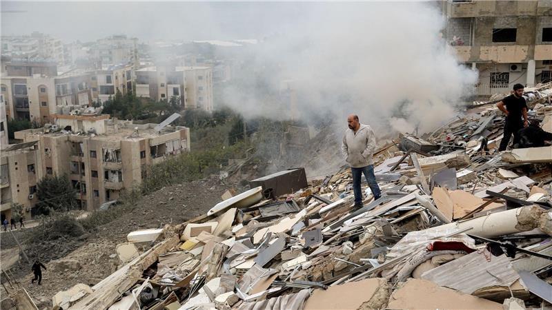 Trümmerfeld: Menschen begutachten die Schäden an einem Gebäude, das bei einem israelischen Luftangriff auf das südlibanesische Dorf Qnarit zerstört wurde.