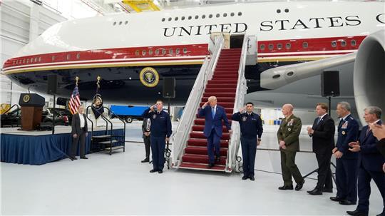 Trump salutiert auf der Gangway des geschenkten Flugzeugs.